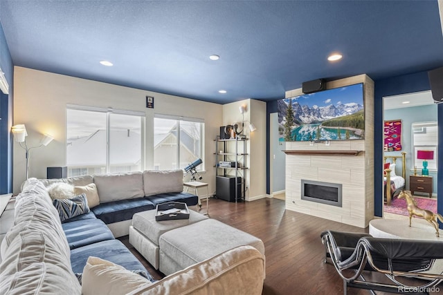 living area with recessed lighting, wood-type flooring, a fireplace, and baseboards