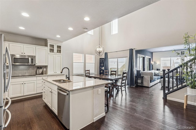 kitchen featuring appliances with stainless steel finishes, a wealth of natural light, white cabinetry, and dark wood-style floors