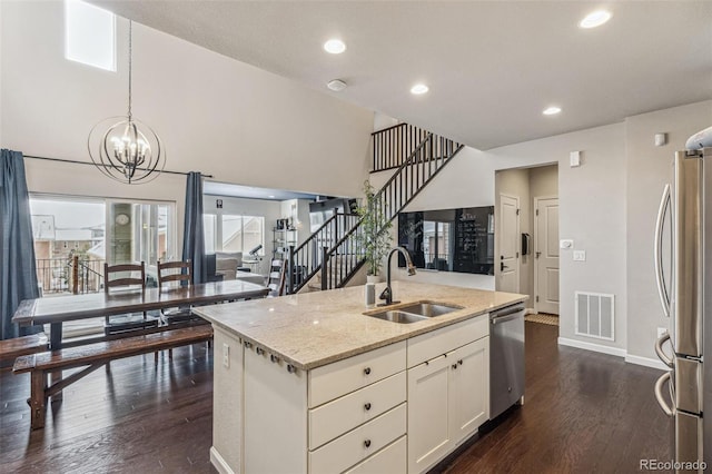 kitchen featuring appliances with stainless steel finishes, dark wood finished floors, visible vents, and a sink