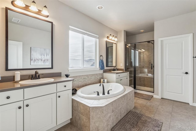 bathroom with a stall shower, tile patterned floors, a sink, and a bath