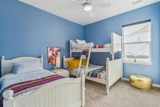 carpeted bedroom featuring ceiling fan, visible vents, and baseboards