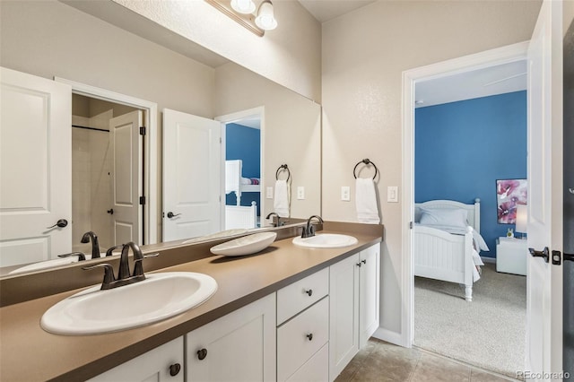 ensuite bathroom featuring tile patterned flooring, double vanity, a sink, and ensuite bathroom