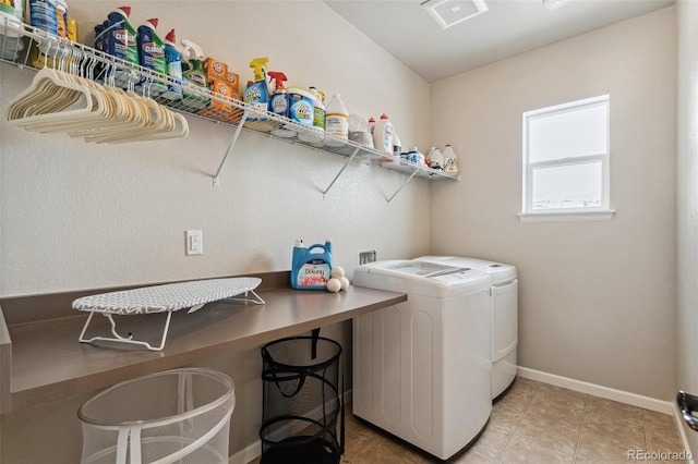 laundry room featuring light tile patterned floors, laundry area, separate washer and dryer, and baseboards