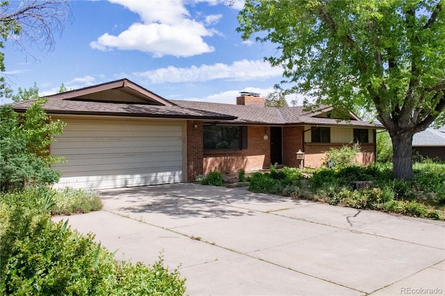 962 S Beech St, Lakewood, CO 80228 - single story home featuring brick siding, an attached garage, concrete driveway, and a chimney