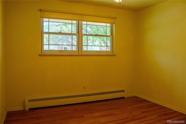 962 S Beech St, Lakewood, CO 80228 - spare room featuring a baseboard heating unit, baseboards, and wood finished floors