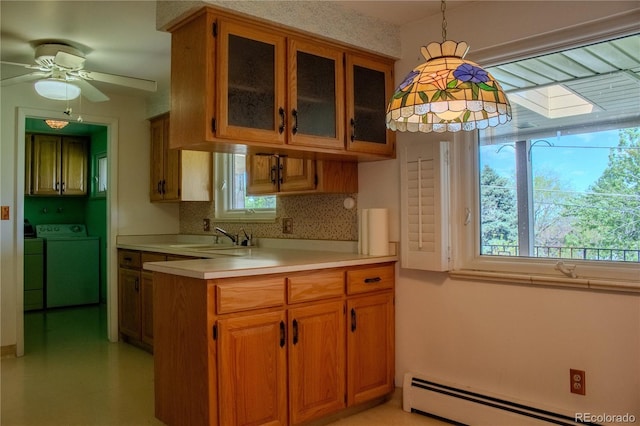 962 S Beech St, Lakewood, CO 80228 - kitchen featuring washing machine and dryer, a sink, light countertops, a baseboard radiator, and brown cabinetry