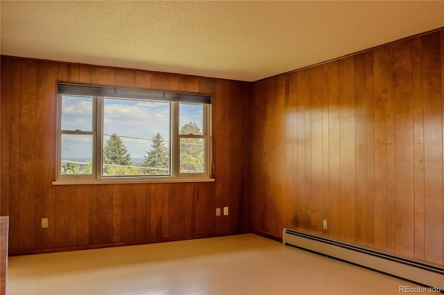 962 S Beech St, Lakewood, CO 80228 - unfurnished room with a baseboard radiator, plenty of natural light, wood walls, and a textured ceiling