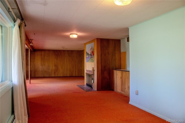 962 S Beech St, Lakewood, CO 80228 - carpeted empty room with a fireplace with flush hearth, wood walls, and a baseboard heating unit
