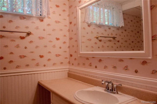 962 S Beech St, Lakewood, CO 80228 - bathroom with wallpapered walls, wainscoting, and vanity