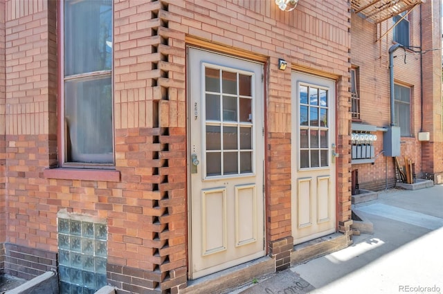 doorway to property featuring brick siding
