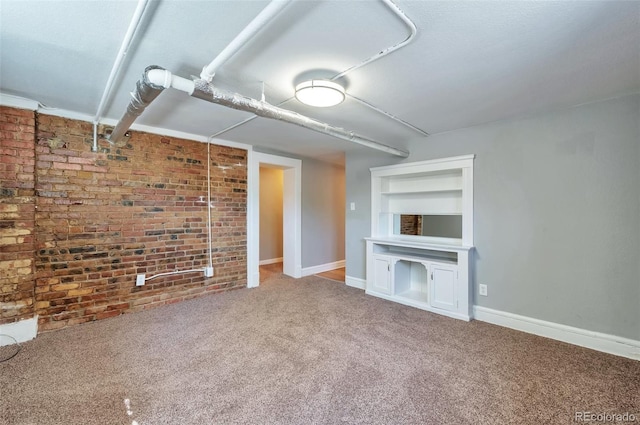 unfurnished living room featuring baseboards, brick wall, and carpet