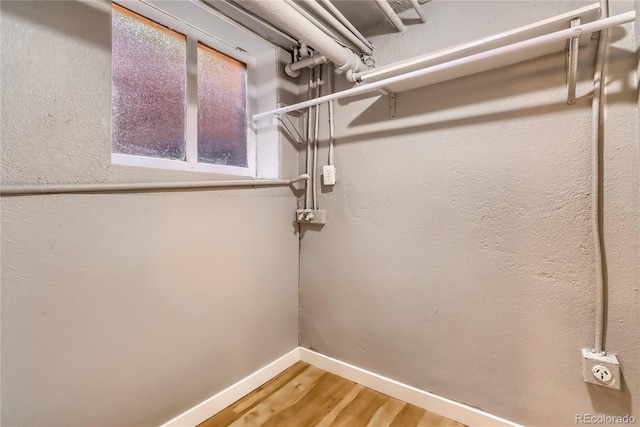 walk in closet with light wood-style floors