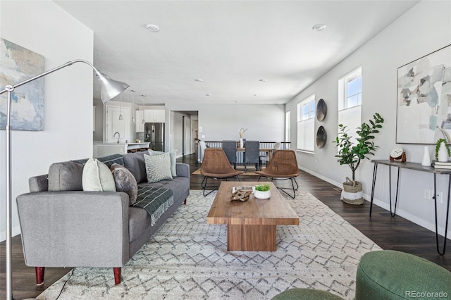 living area with baseboards and wood finished floors