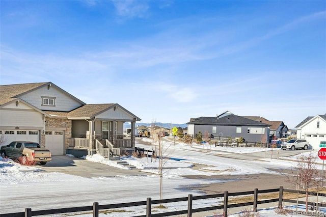 view of front of property featuring a porch, concrete driveway, fence, and a residential view