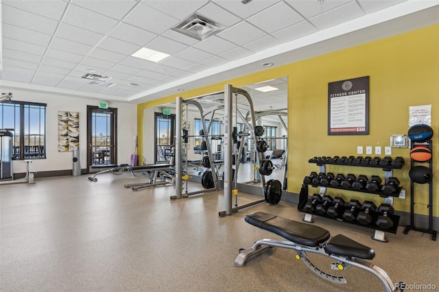 workout area featuring a drop ceiling, visible vents, and baseboards