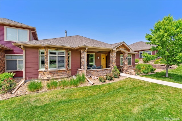 8595 Gold Peak Dr Unit A, Highlands Ranch, CO 80130 - view of front of property with stone siding, a front lawn, and a shingled roof