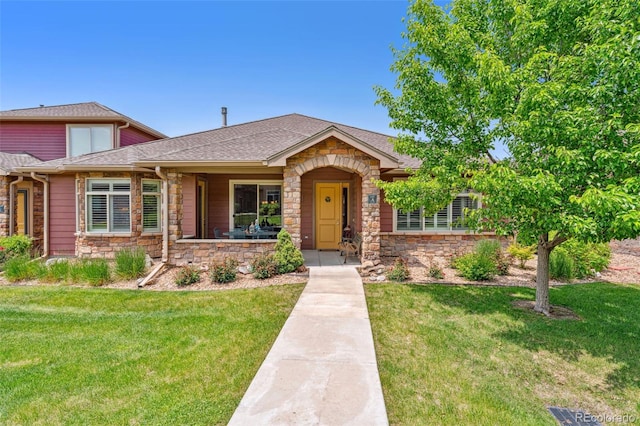 8595 Gold Peak Dr Unit A, Highlands Ranch, CO 80130 - view of front of property with stone siding, a front yard, and roof with shingles