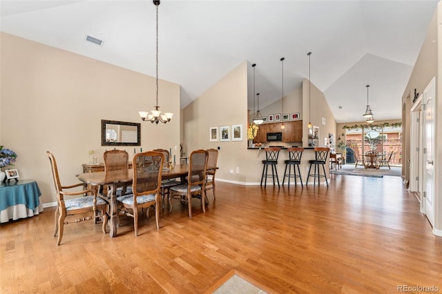 8595 Gold Peak Dr Unit A, Highlands Ranch, CO 80130 - dining room with light wood-type flooring, high vaulted ceiling, baseboards, and a chandelier