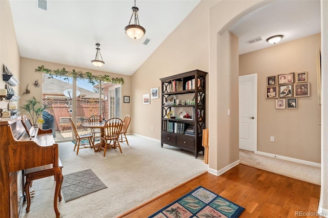 8595 Gold Peak Dr Unit A, Highlands Ranch, CO 80130 - carpeted dining space with arched walkways, wood finished floors, baseboards, and lofted ceiling