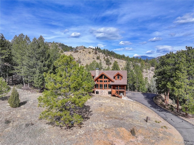 14753 Kit Carson Peak Trl, Pine, CO 80470 - view of front of home featuring driveway, a mountain view, and a chimney