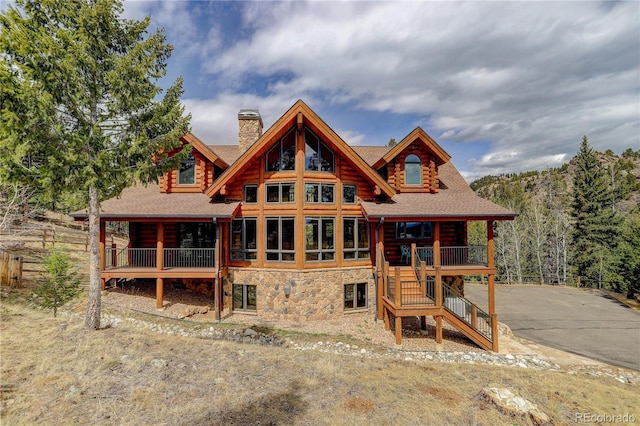 14753 Kit Carson Peak Trl, Pine, CO 80470 - view of front of house featuring a chimney, roof with shingles, log siding, stairs, and stone siding