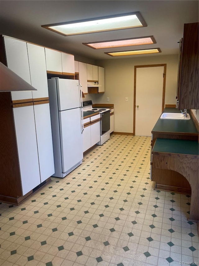 kitchen with sink, white appliances, and white cabinets