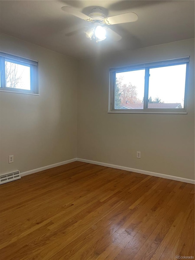 unfurnished room featuring ceiling fan, plenty of natural light, and hardwood / wood-style floors