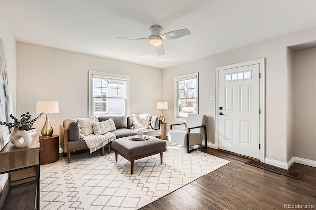 living area with light wood-style floors, baseboards, and ceiling fan