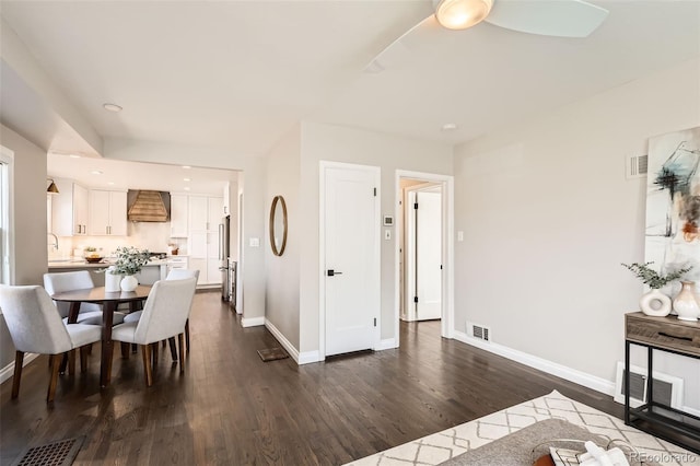 dining room with visible vents, baseboards, and dark wood-style flooring