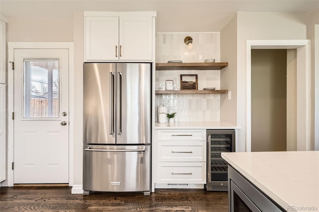 kitchen featuring wine cooler, white cabinetry, stainless steel appliances, and dark wood-type flooring