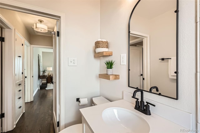 bathroom with vanity, toilet, and wood finished floors