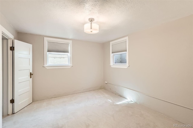 spare room featuring a textured ceiling and carpet