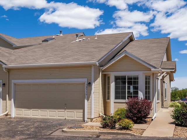 12335 E 2nd Dr, Aurora, CO 80011 - view of front of house with roof with shingles, driveway, and an attached garage
