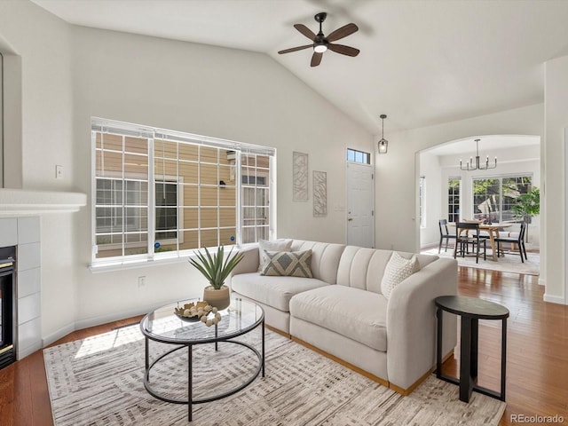 12335 E 2nd Dr, Aurora, CO 80011 - living room featuring wood finished floors, arched walkways, a chandelier, vaulted ceiling, and a ceiling fan