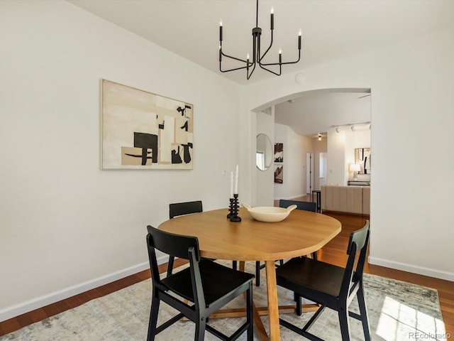 12335 E 2nd Dr, Aurora, CO 80011 - dining space with arched walkways, baseboards, a chandelier, and wood finished floors
