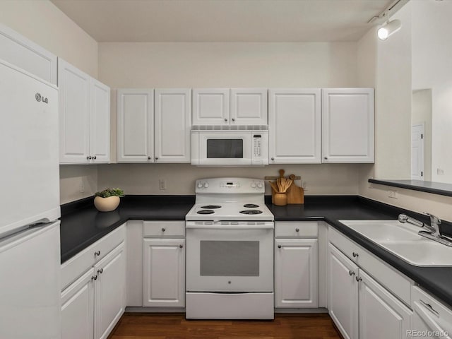 12335 E 2nd Dr, Aurora, CO 80011 - kitchen with white appliances, a sink, dark countertops, and white cabinetry