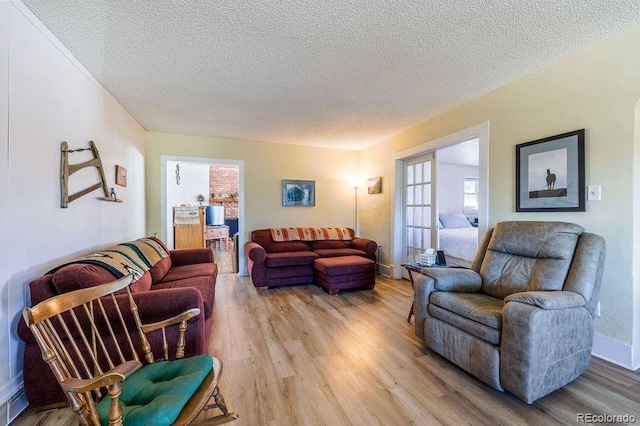 living room featuring a textured ceiling and light hardwood / wood-style floors