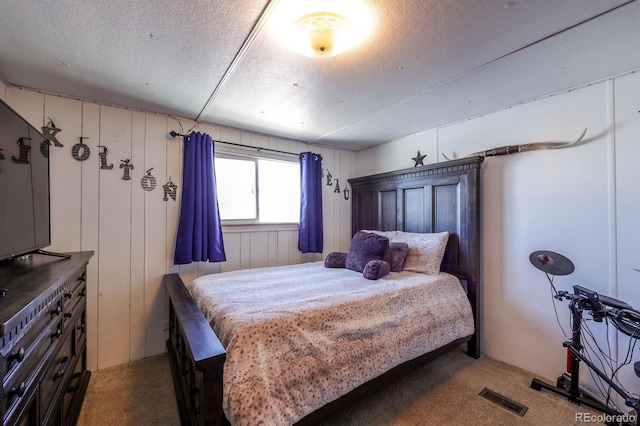 bedroom with carpet flooring, a textured ceiling, and wooden walls