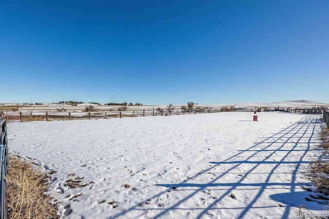 snowy yard featuring a rural view