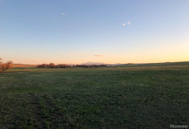 nature at dusk featuring a mountain view and a rural view