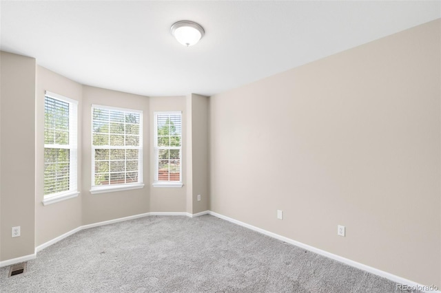 carpeted empty room with baseboards