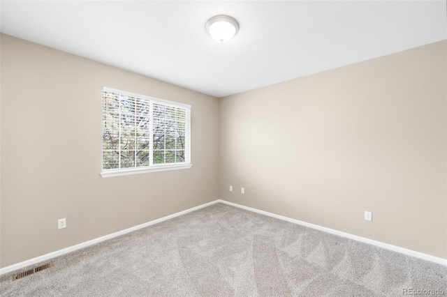 spare room featuring carpet floors and baseboards