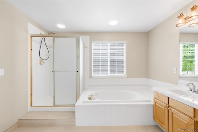 bathroom with vanity, a shower stall, and a garden tub