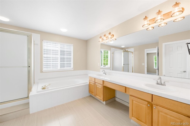 bathroom with a stall shower, a bath, and double vanity