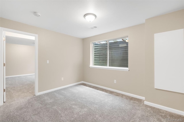 carpeted empty room with a smoke detector and baseboards