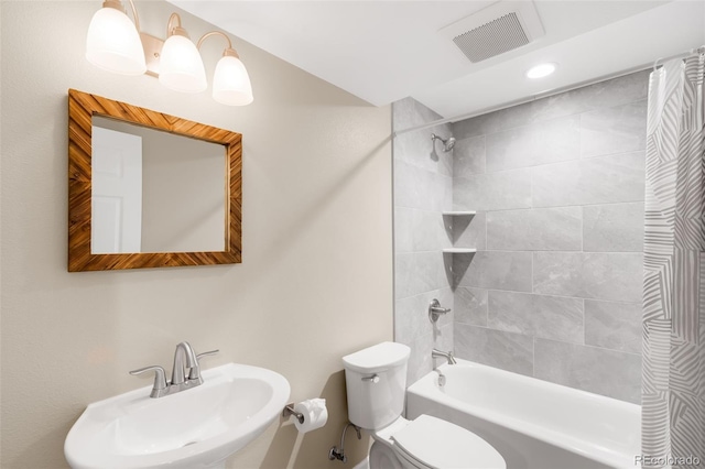 bathroom with a sink, toilet, shower / bath combo with shower curtain, and recessed lighting