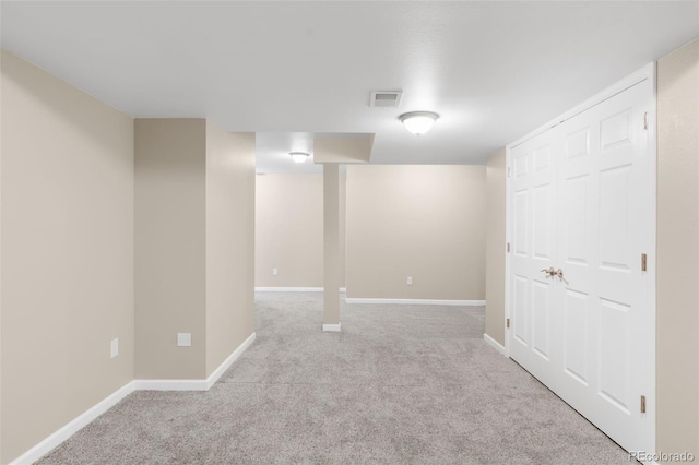finished below grade area featuring light carpet and baseboards