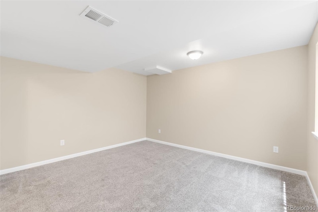 empty room featuring carpet and baseboards