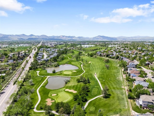 view of property location with nearby suburban area, a water and mountain view, and a local golf course