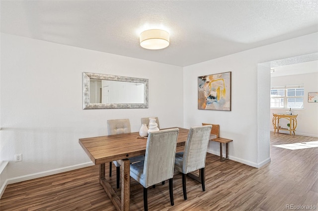 dining area with hardwood / wood-style flooring and a textured ceiling